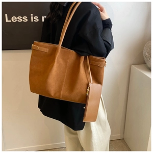 Gros plan sur un sac cabas en daim marron avec pochette zippée et détails de texture