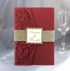 Detail of laser-cut burgundy invitation with golden glitter band and custom name tag