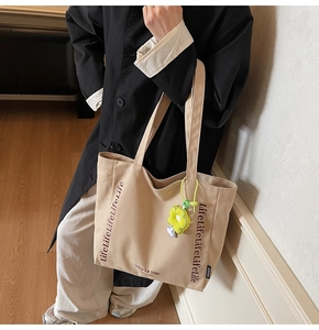 Detail of canvas tote bag showing LifeLifeLifeLife text and yellow sunflower charm
