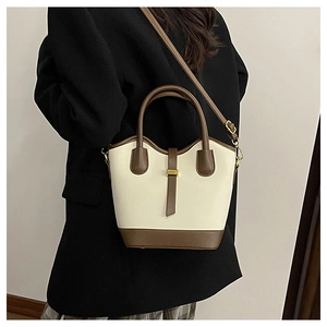 Détail d'un sac seau vintage avec contraste en cuir marron et finitions dorées