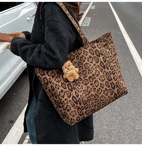 Detail of leopard print tote bag with plush bear charm and spacious canvas interior