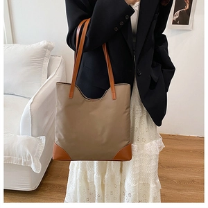 Detailed view of a two-tone large tote bag with brown leather accents and khaki fabric