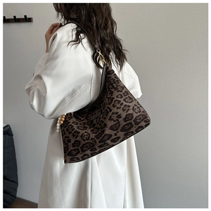 Detail der Hobo-Tasche mit Leopardenmuster, Holzperlen und dunklem Lederriemen