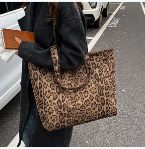 Detailed macro view of leopard print tote bag fabric and spacious side profile design