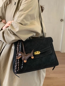 Retro large capacity black shoulder bag with gold clasp and dog charm on trench coat model