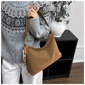 Detail einer braunen matten Hobo-Tasche mit Holzperlen-Quaste und Reißverschluss
