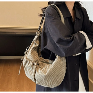 Detail of the checkered canvas hobo bag showing bow tie accents and pleated design