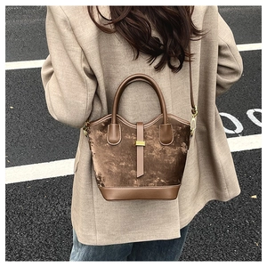 Détail du sac seau en velours marron avec garniture en cuir synthétique et boucles en métal