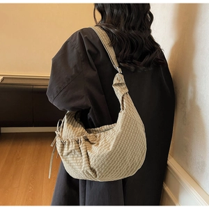 Detail view of khaki checkered canvas half-moon bag with drawstring and wide strap