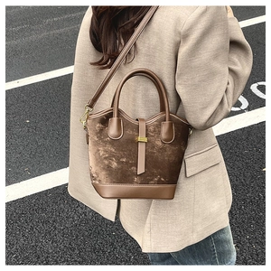 Détail d'un sac bandoulière vintage en daim marron avec boucle dorée et cuir assorti