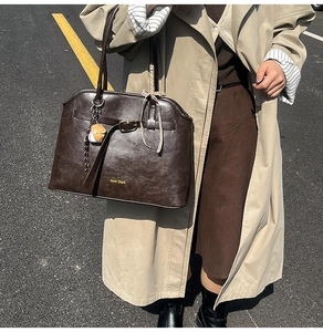 Detail of dark brown faux suede tote bag with metal buckle and plaid silk scarf accent