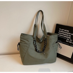 Dettaglio della borsa tote verde oliva con coulisse e capienti tasche laterali