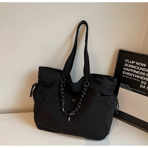 Dettaglio della borsa tote nera in tela con bordo in corda e logo in metallo