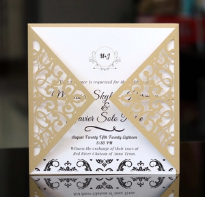 Elegante goldene lasergeschnittene Hochzeitseinladung mit weißer Karte auf schwarzem Grund