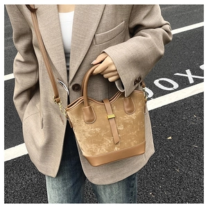 Détail de rue d'un sac seau bandoulière caramel vintage avec boucle dorée élégante