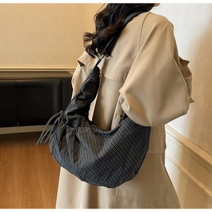 Detail of grey checkered canvas crescent bag with drawstring pleated side and spacious design
