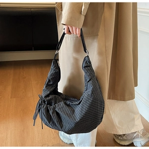 Detail of checkered canvas hobo bag showing bow tie knots and gathered texture