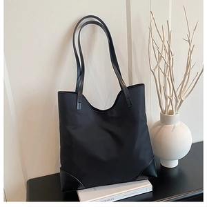 Close-up of black tote bag with synthetic leather base detail in a lifestyle setting