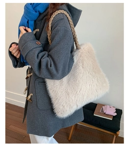 Detail of soft cream faux fur tote bag featuring durable dark brown braided rope straps