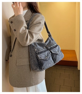Détail d'un sac cabas en denim gris délavé avec plusieurs poches et rivets argentés