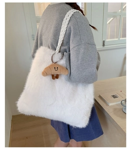 Detailed side view of white plush tote bag with a croissant charm and braided strap