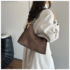 Detailaufnahme der dunkelbraunen Wildleder-Hobo-Tasche mit Vintage-Perlenanhänger