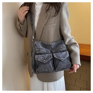 Gros plan du sac en denim gris vintage avec plusieurs poches et fermetures éclair
