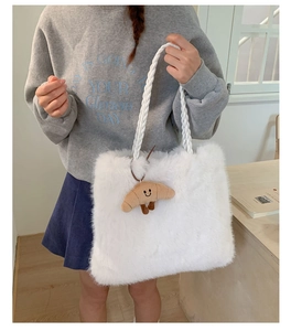 Detail of white faux fur tote bag with woven rope handle and croissant plush charm