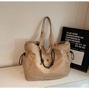 Dettaglio della borsa tote in tela con tasche laterali a coulisse e corda intrecciata