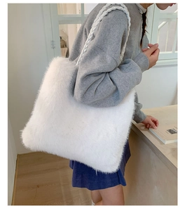 Detail view of a large white plush tote bag with thick woven shoulder straps and soft texture