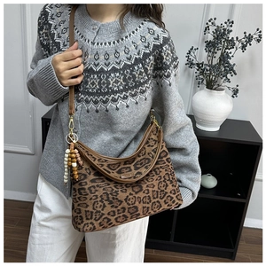 Detail der Schultertasche mit Leopardenmuster, Perlenanhänger und Lederbesatz