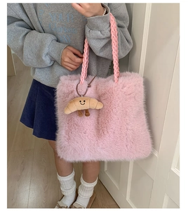 Pink plush tote bag detail with thick woven handle and cute croissant pendant