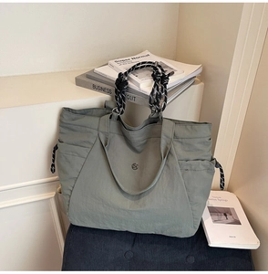 Dettaglio della borsa tote in tela grigio-verde con manici intrecciati e coulisse