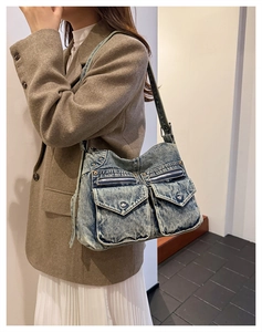 Détail d'un cabas vintage en denim délavé avec poches plaquées et fermetures éclair métalliques