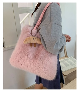 Detailed close-up of a pink faux fur tote bag with a cute croissant plush pendant