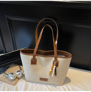 Détail du cabas en toile avec anses en cuir PU marron et pendentif en perles coloré