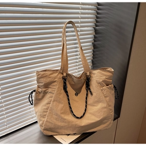 Dettaglio della borsa tote in nylon beige con chiusura a coulisse e manici in corda