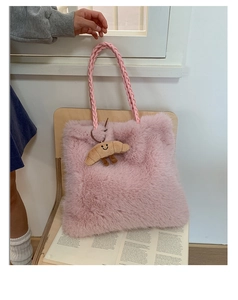 Detail of pink faux fur tote bag with woven handles and cute croissant plush pendant