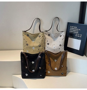 Four colors of embroidered canvas tote bags displayed on a clean white platform