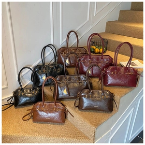 Collection of retro leather tote bags in various colors on steps with gold hardware