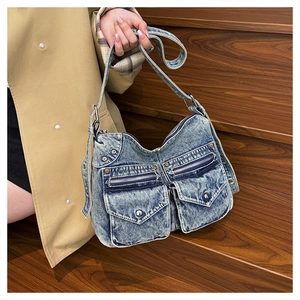 Détail d'un sac cabas en denim délavé vintage avec plusieurs poches et fermetures éclair