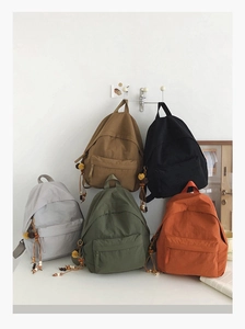 Detail showing high-capacity backpacks in five colors with unique tassel decorations