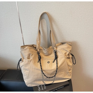 Dettaglio borsa tote in nylon beige con manici in corda intrecciata e tasche laterali