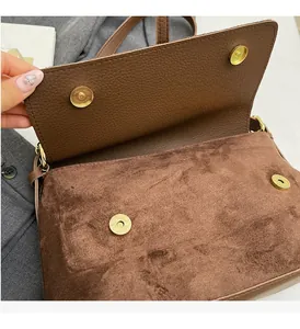 Detail of vintage brown leather bag showing dual magnetic closure and gold hardware