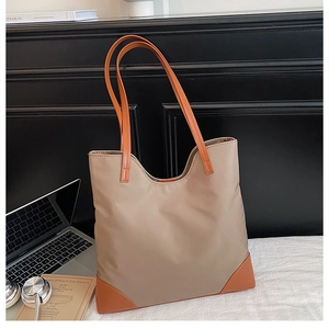 Detail view of khaki tote bag with orange handles and reinforced corners for daily use