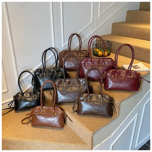 Detail view of four vintage leather Boston bags in black, coffee, burgundy and caramel