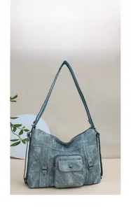 Detail of teal washed canvas bag showing adjustable straps and magnetic flap pocket