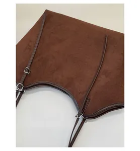 Detail of vintage brown suede tote bag featuring silver metal buckle and fine stitching