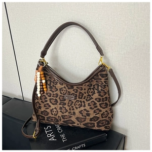 Detail der Leopard-Tasche mit braunem Lederbesatz und Retro-Holzperlen-Anhänger