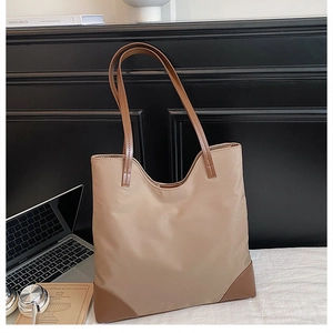 Detailed view of spacious tote bag in khaki nylon with contrasting brown leather handles
